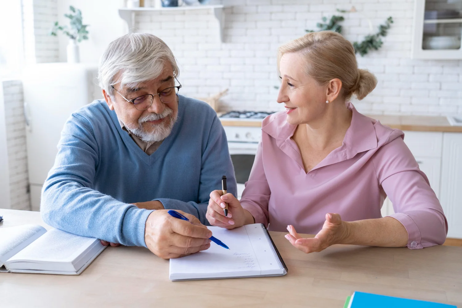 Dos personas mayores calculando en una libreta