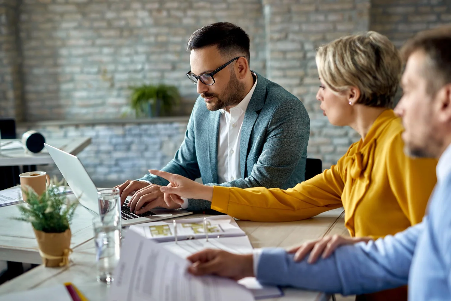 Tres personas mirando los datos del ordenador en una mesa